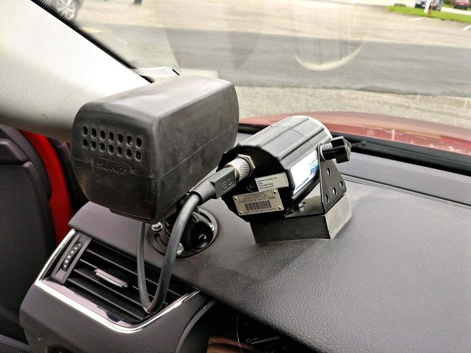 A traffic radar unit mounted on the dashboard of a patrol car