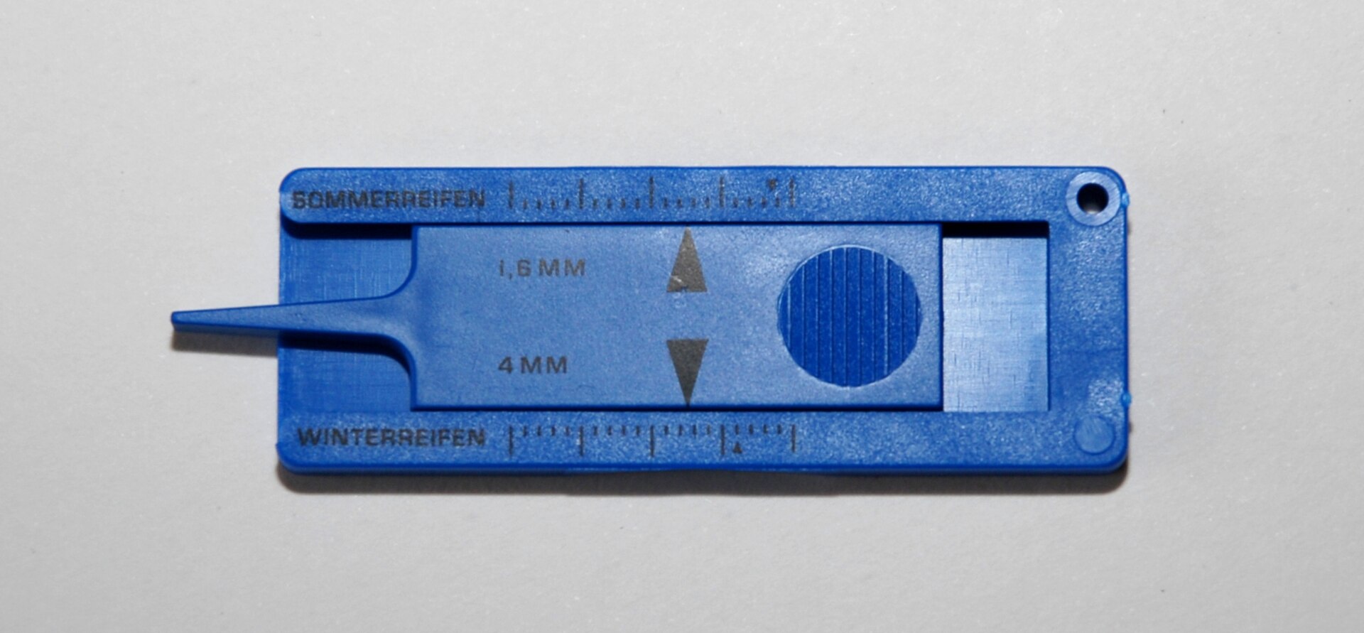 A simple plastic tread depth gauge with markings at 1.6 mm and 4 mm