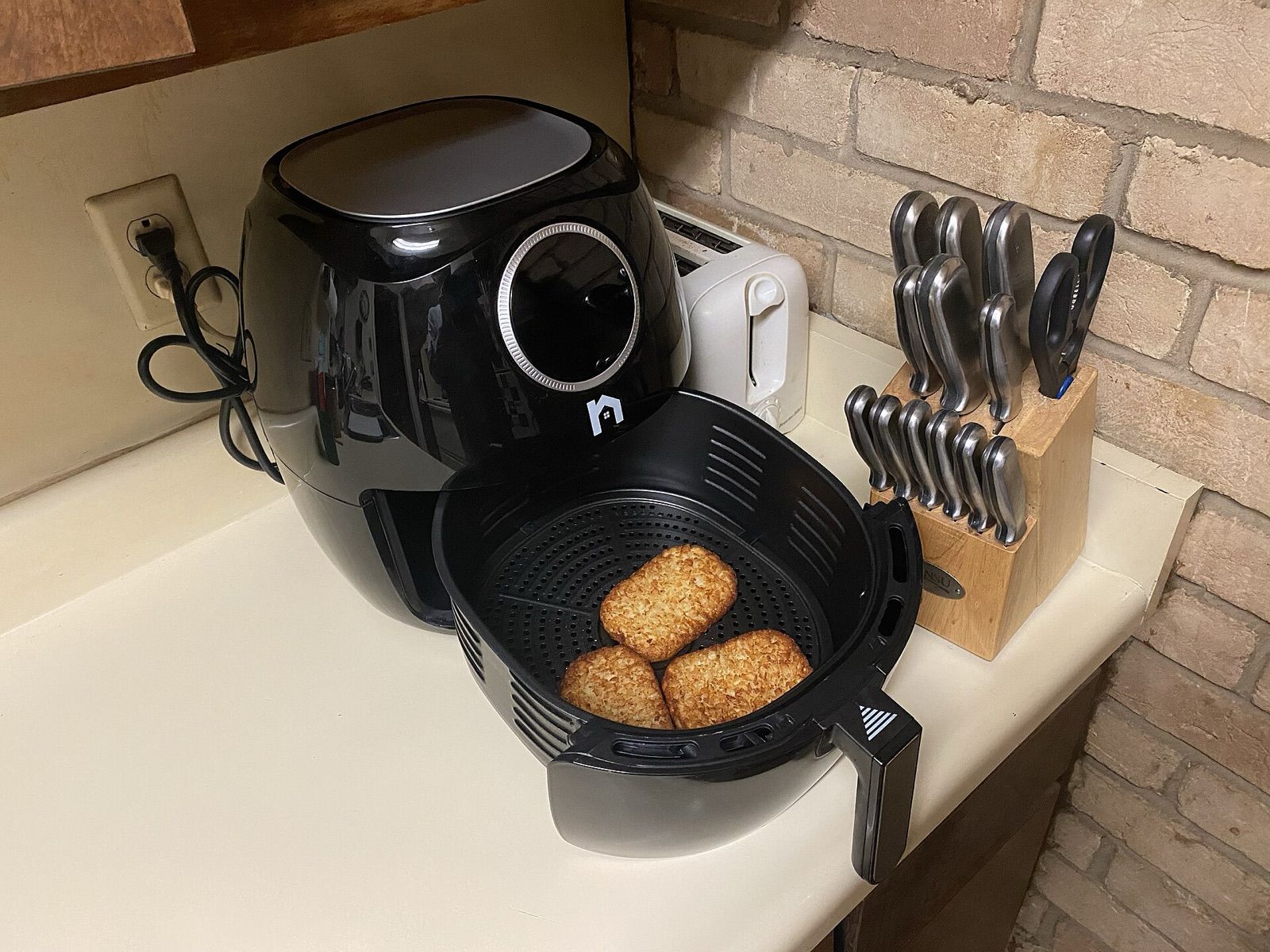 Basket air fryer on a kitchen counter with its drawer pulled out