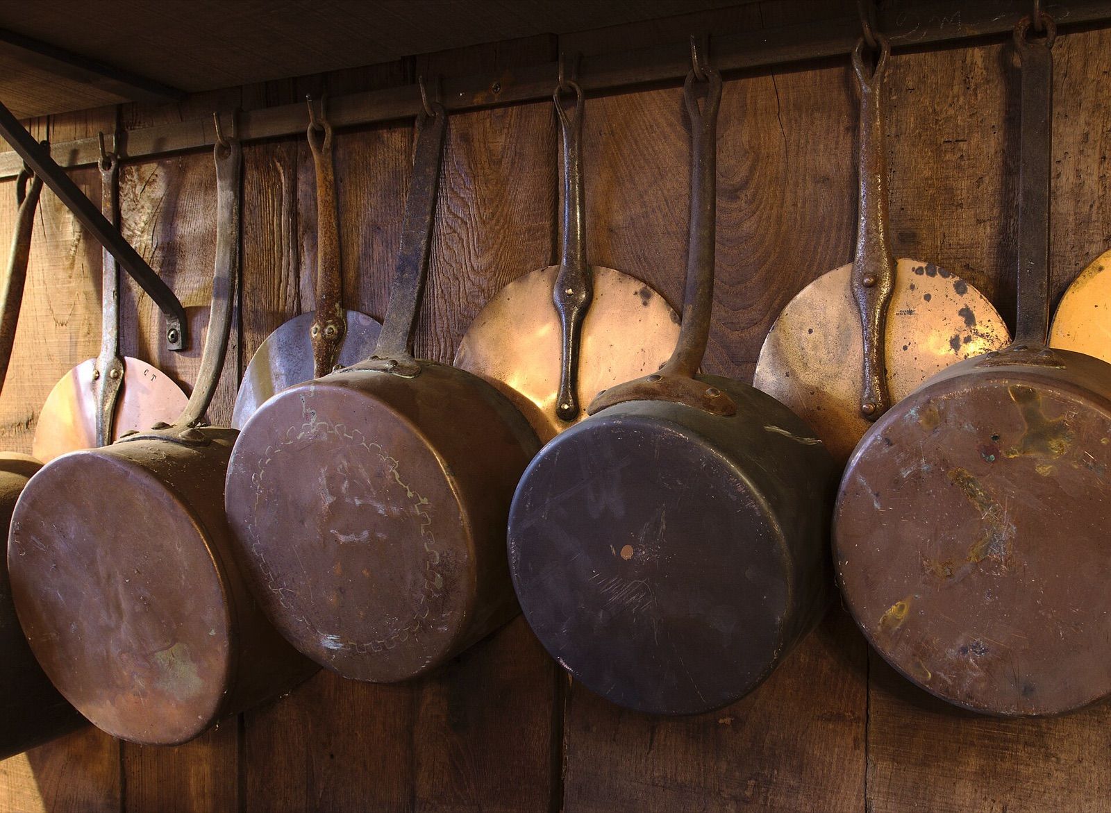Copper pots and lids hanging in a traditional kitchen