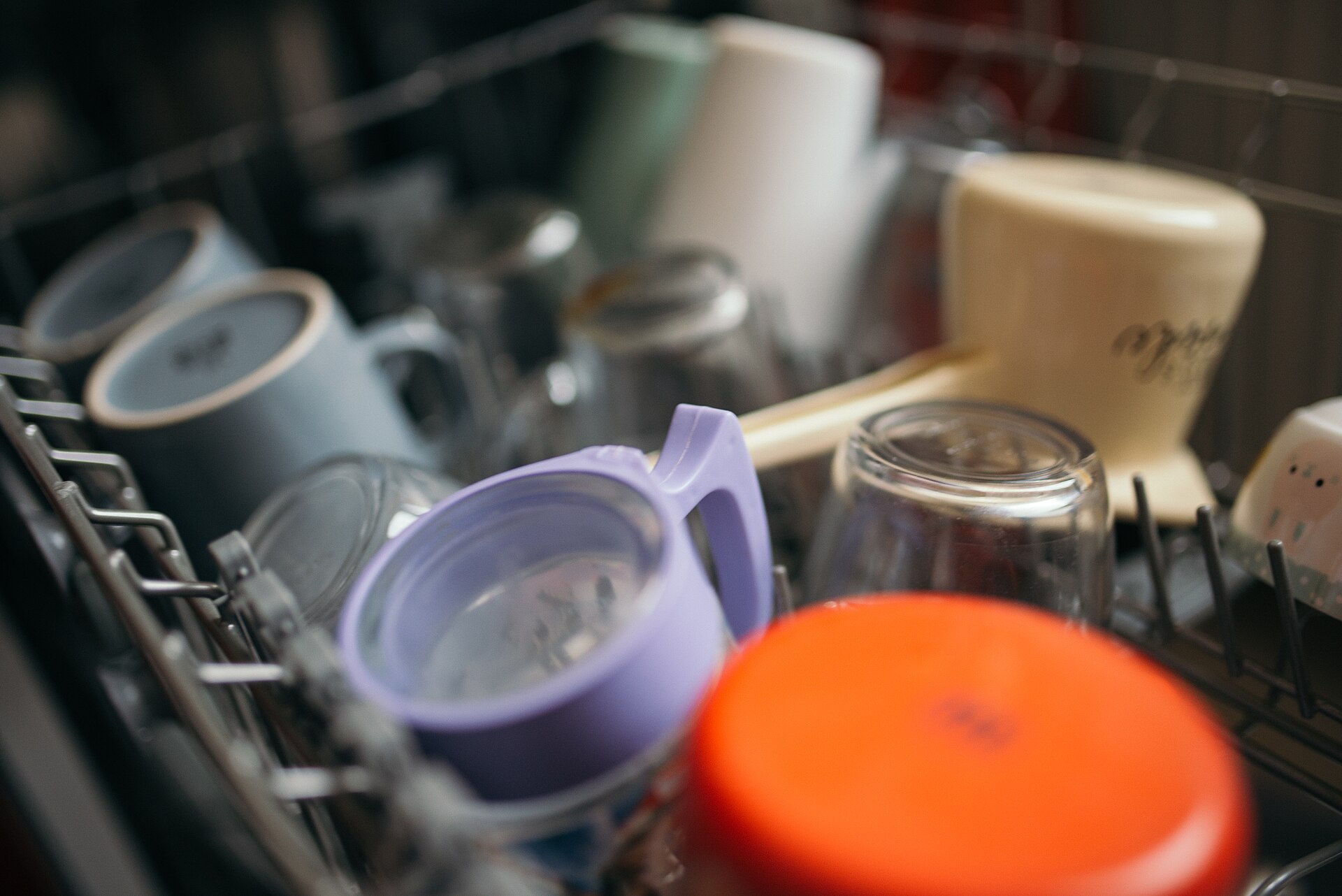 Cups, glasses and containers loaded in the upper rack of a dishwasher