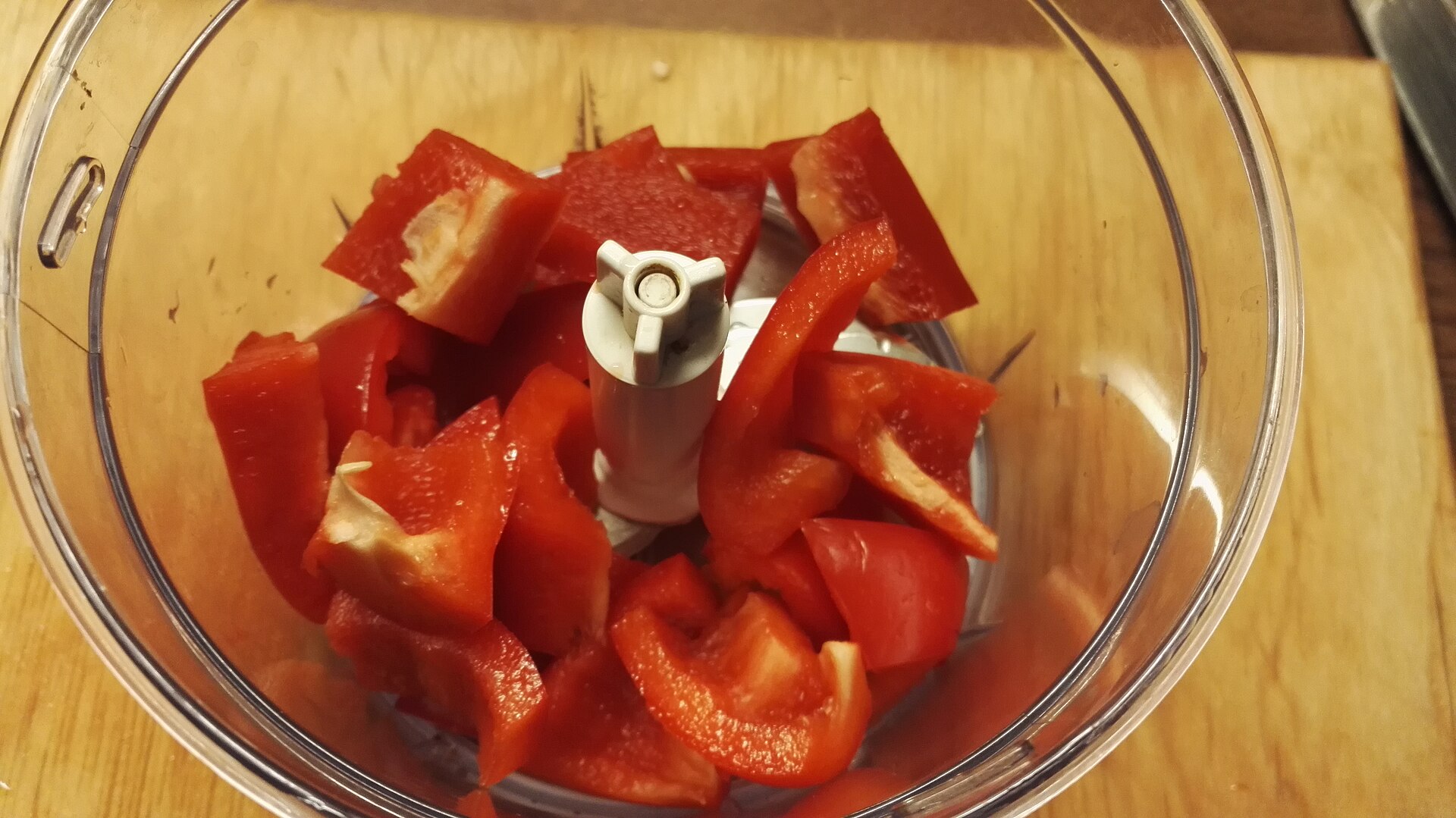 Chopped red pepper in the clear bowl of a small food processor