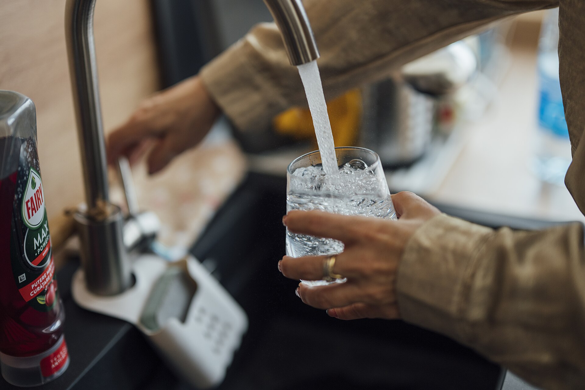 Filling a glass of water at a kitchen sink
