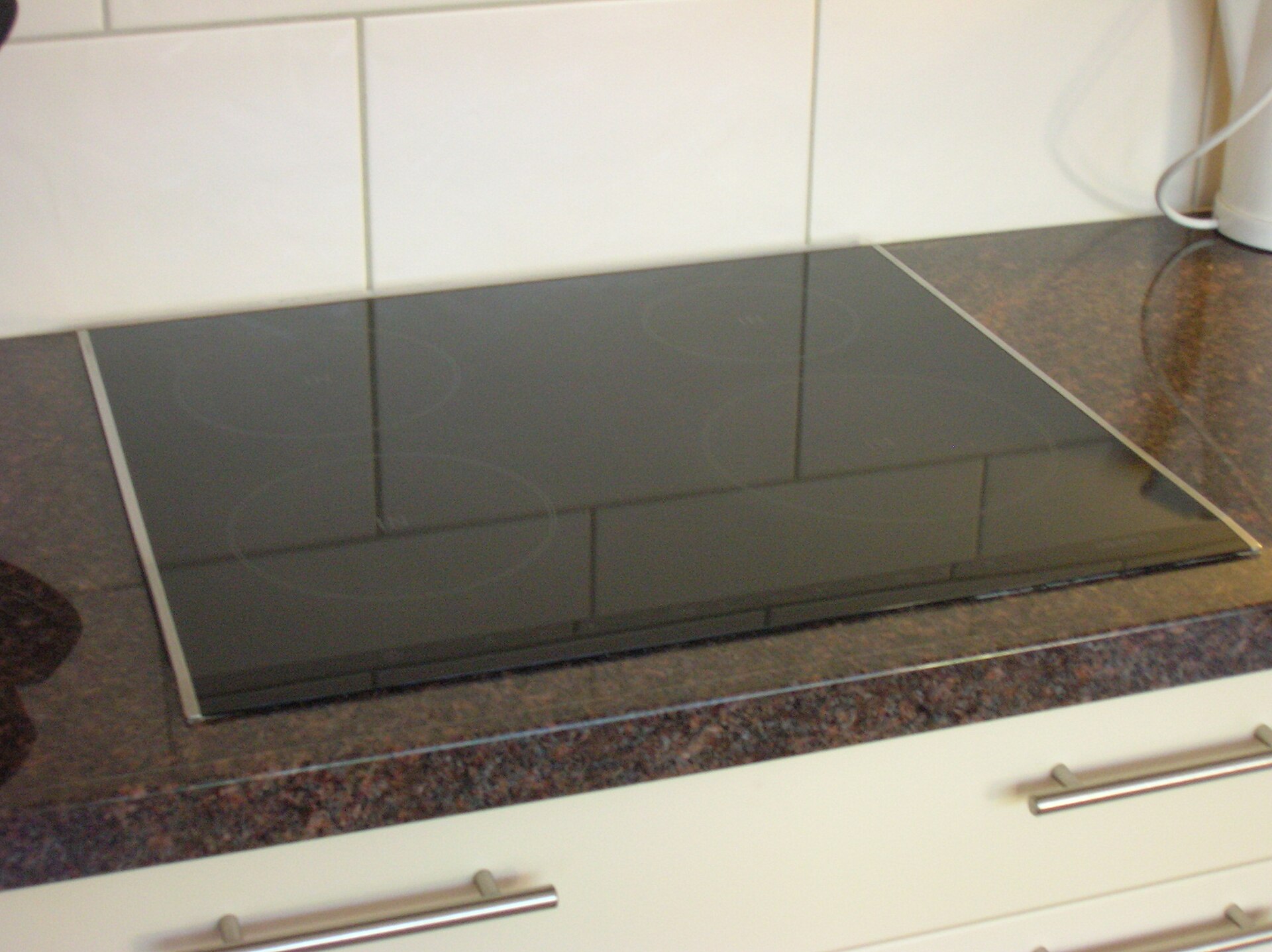 Built-in induction hob with a black glass surface set into a kitchen worktop