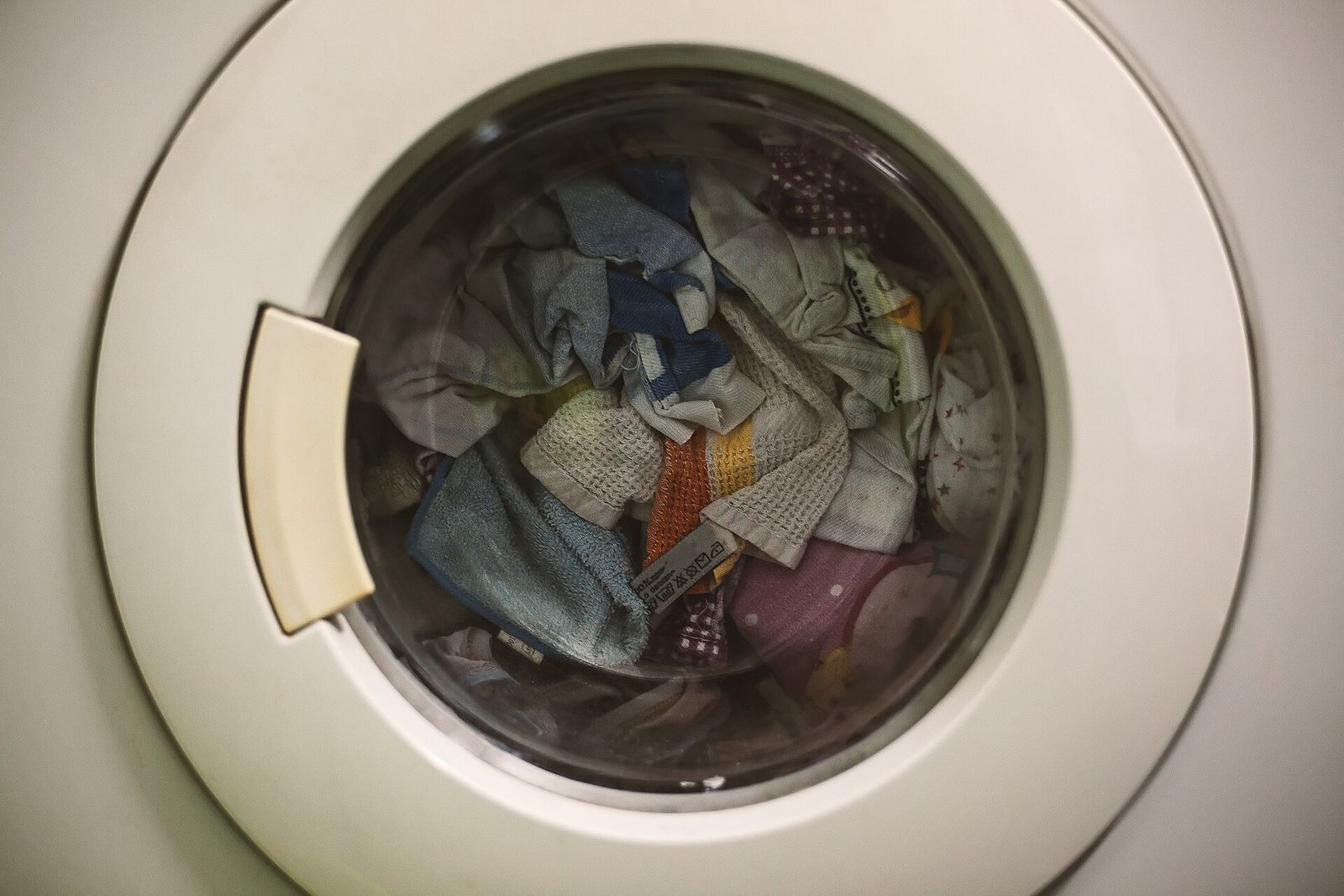 Laundry seen through the glass door of a front-loading washing machine