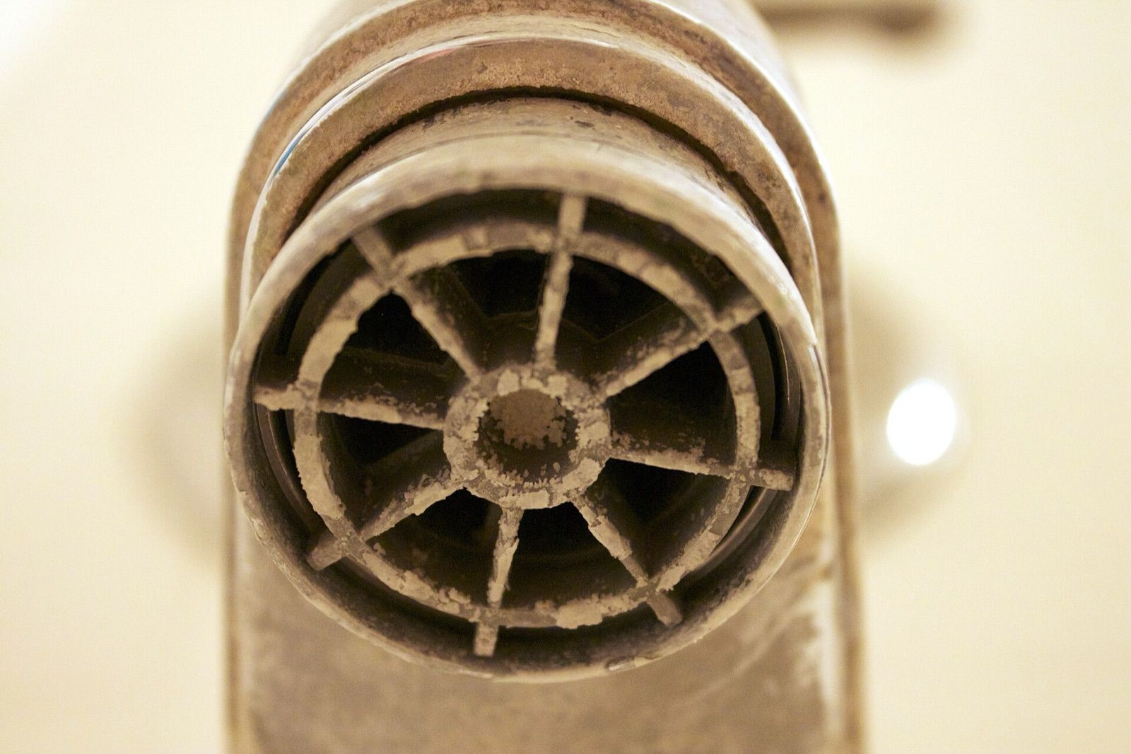 Close-up of a tap outlet crusted with white limescale from hard water