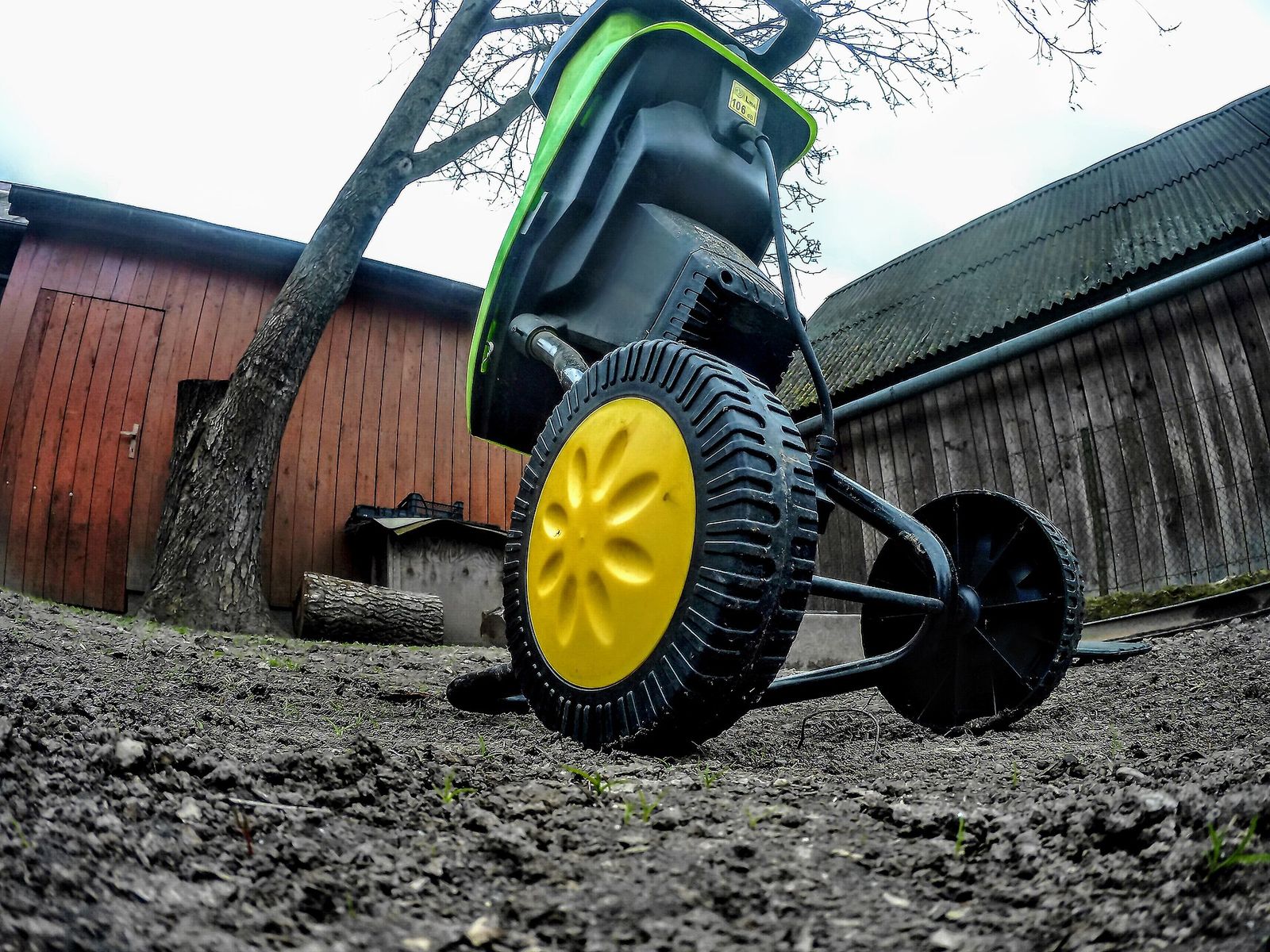 Electric garden shredder on wheels in a back garden, seen from ground level