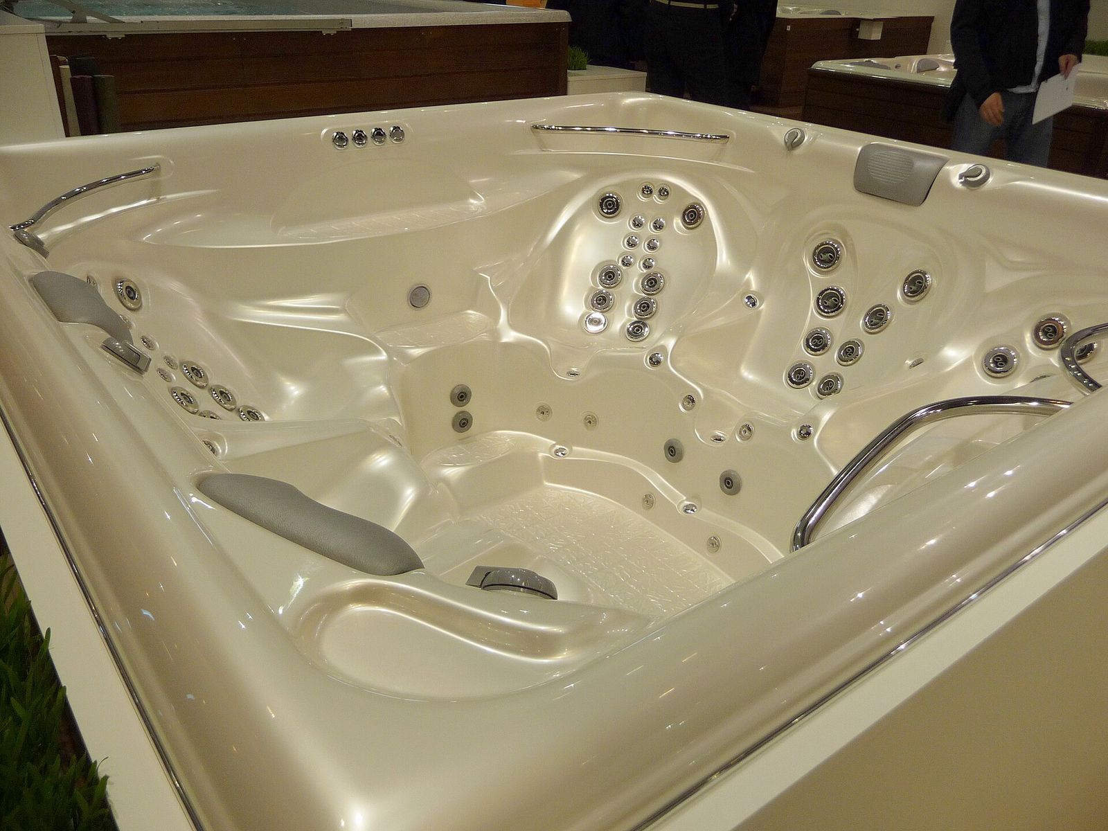 Empty acrylic hot tub with moulded seats, a lounger, headrests and rows of jets