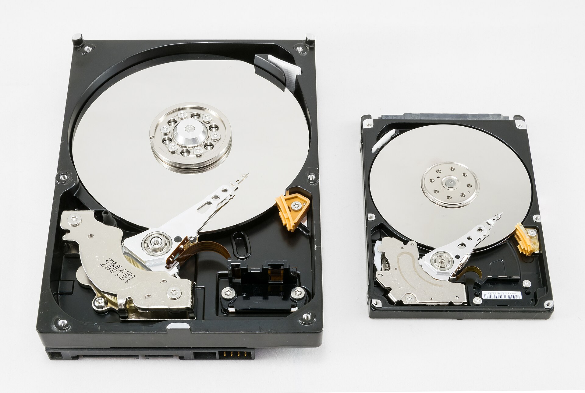 Opened 3.5-inch and 2.5-inch hard drives showing their platters and read arms