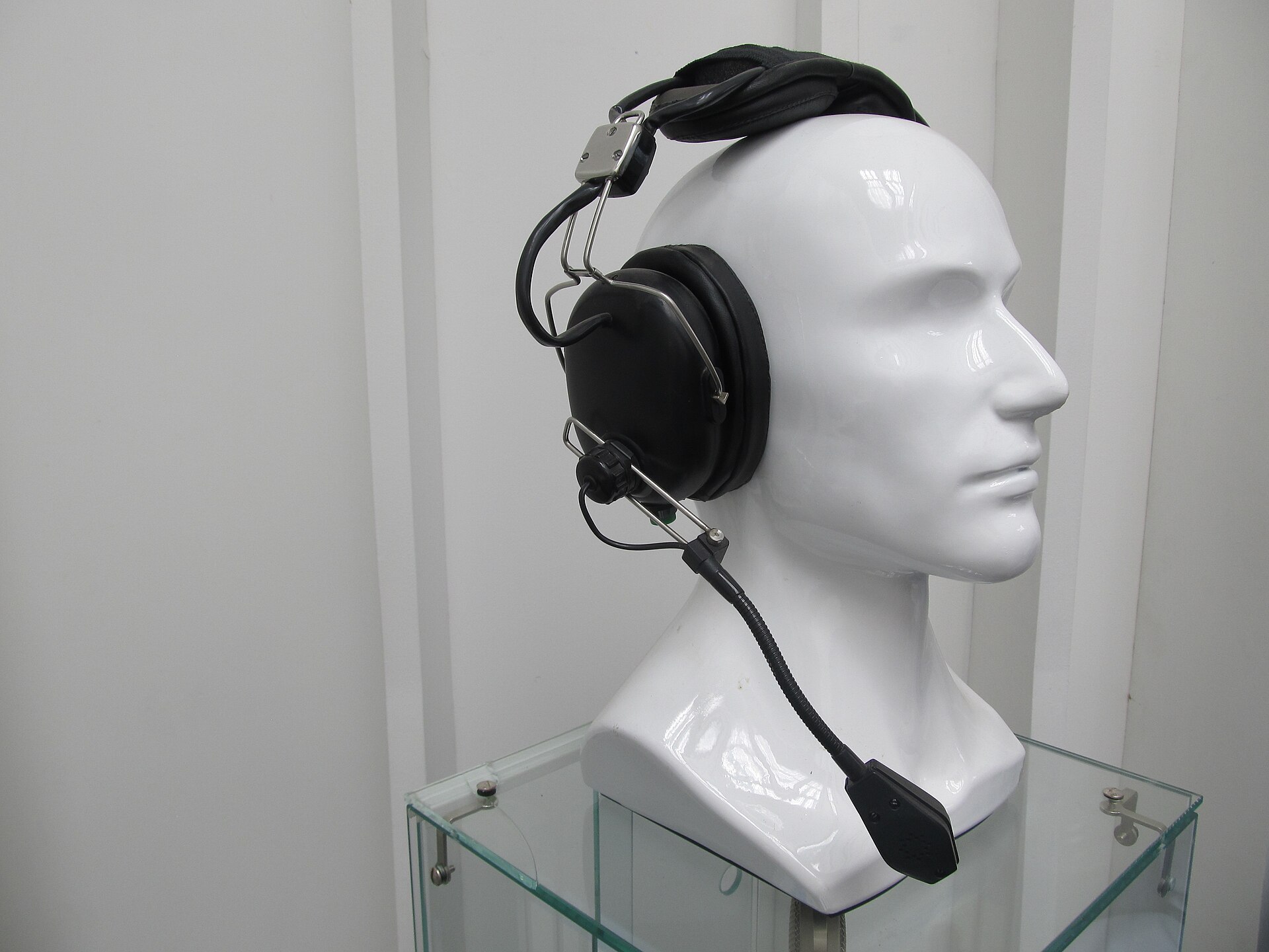 Over-ear headset with a flexible boom microphone displayed on a white mannequin head