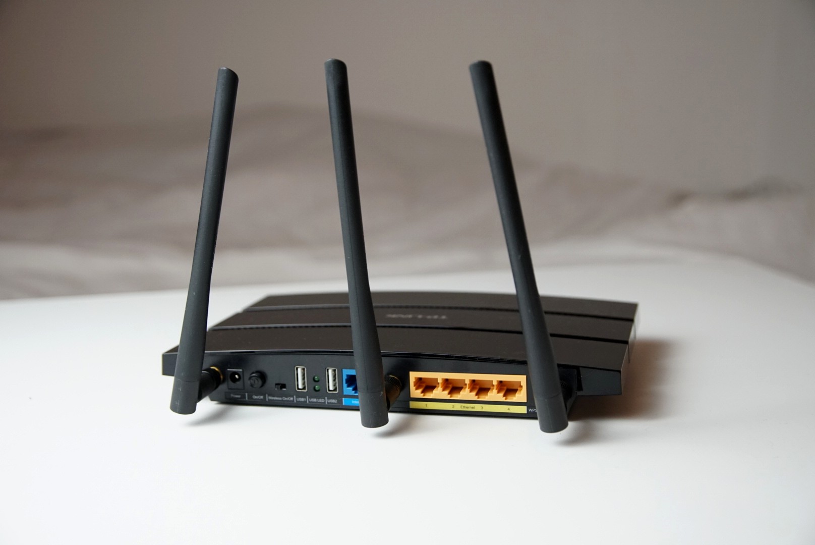 Back of a Wi-Fi router showing antennas and Ethernet ports