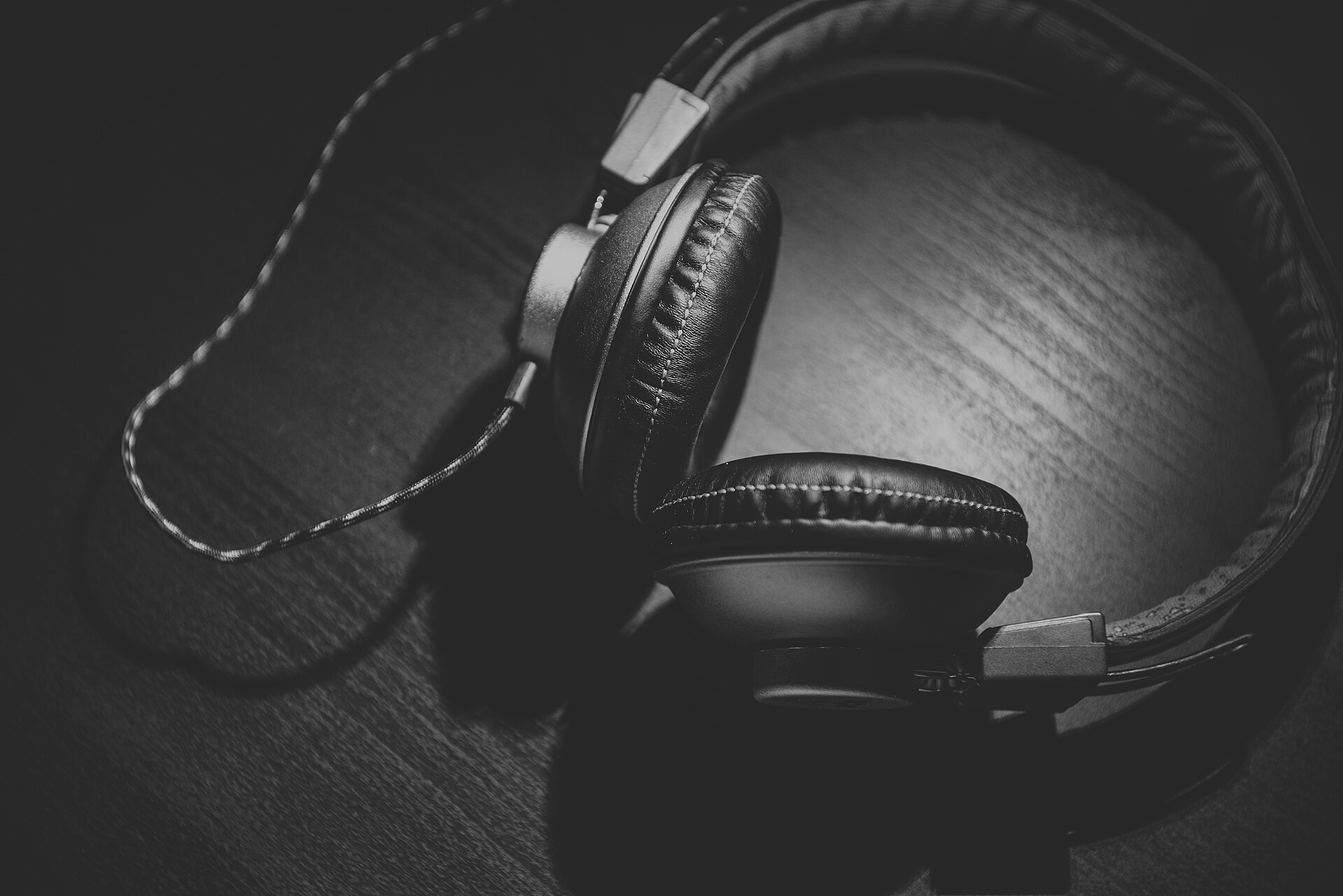 Over-ear headphones with cushioned ear pads resting on a wooden surface