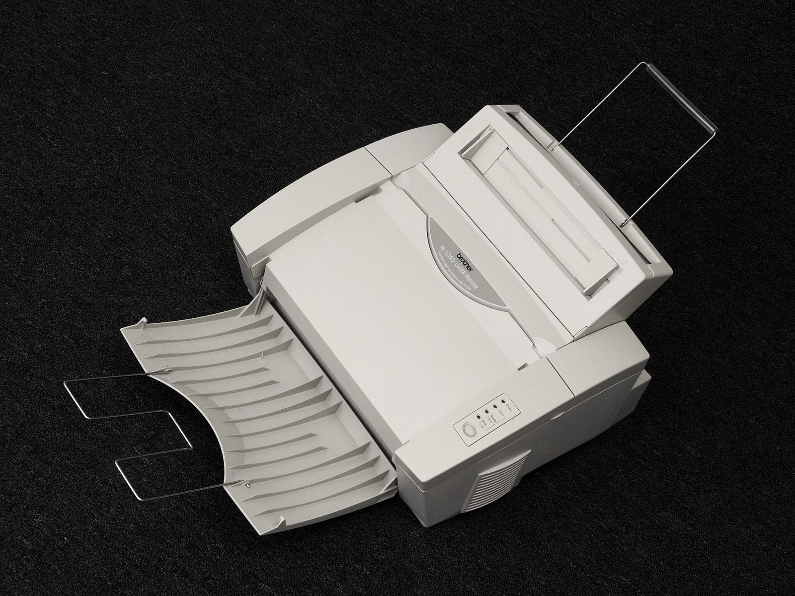 A compact desktop laser printer with its paper trays extended