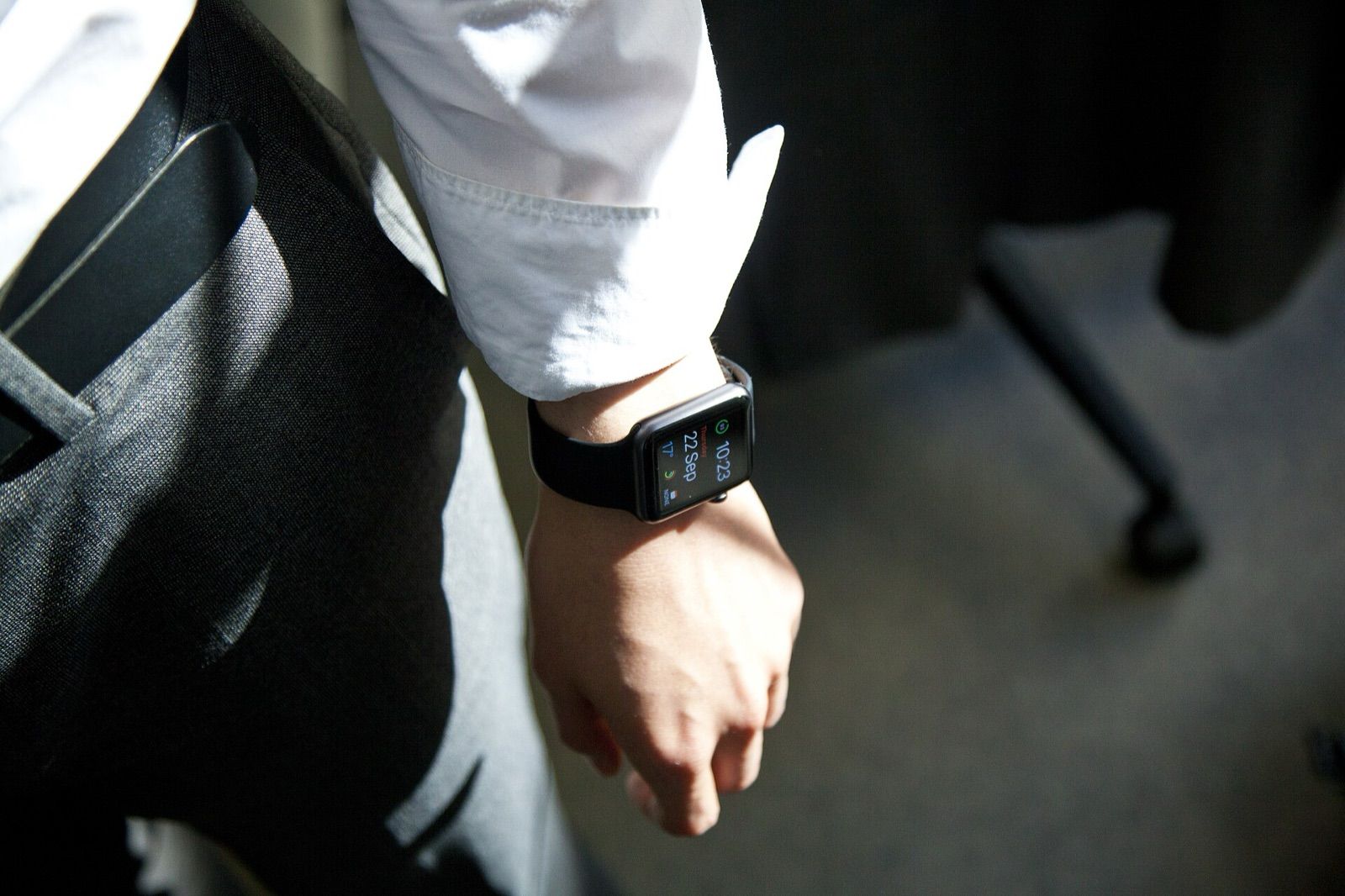 A smartwatch on the wrist of a person in a white shirt
