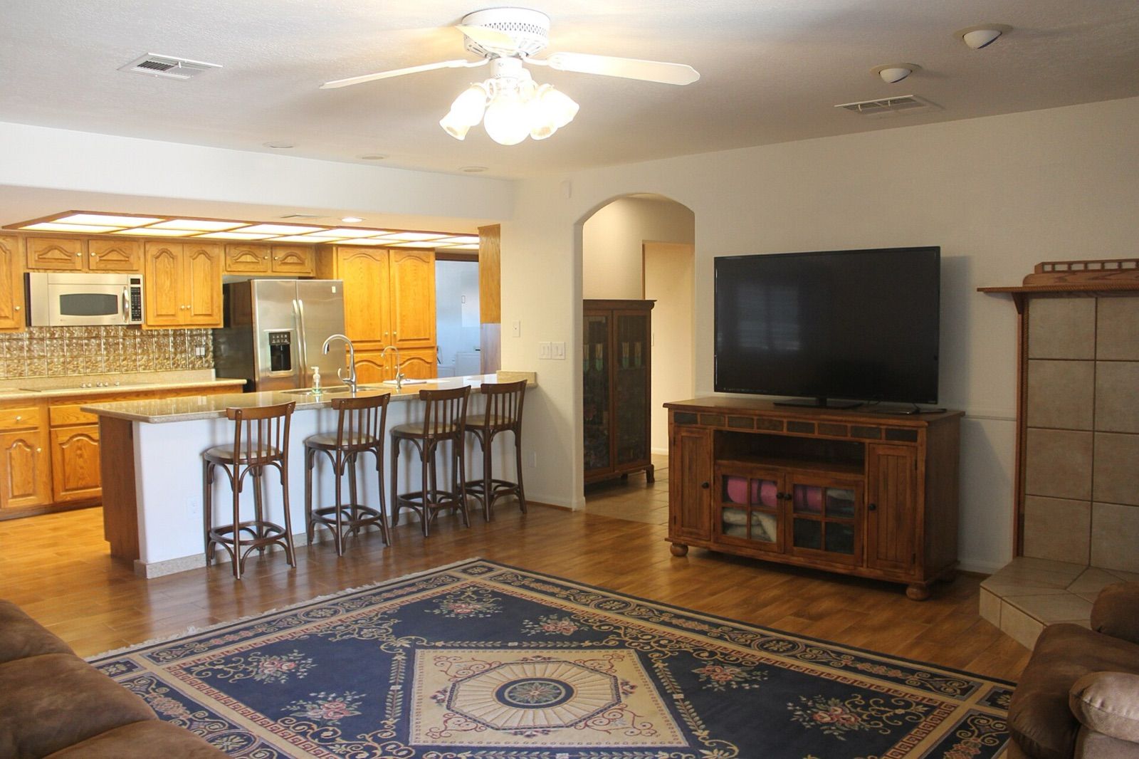 A living room with a flat-screen television on a wooden cabinet