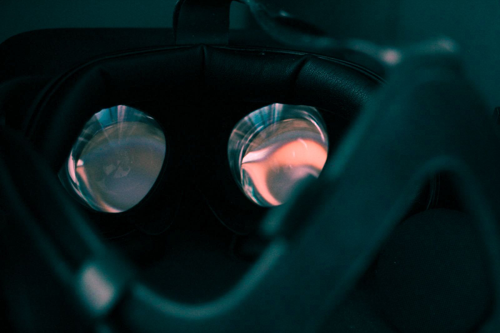 Close-up of the two lenses inside a virtual reality headset, lit by the glow of its displays