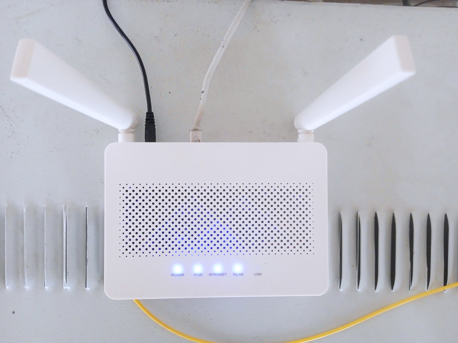 A white wireless router with two external antennas and blue status lights