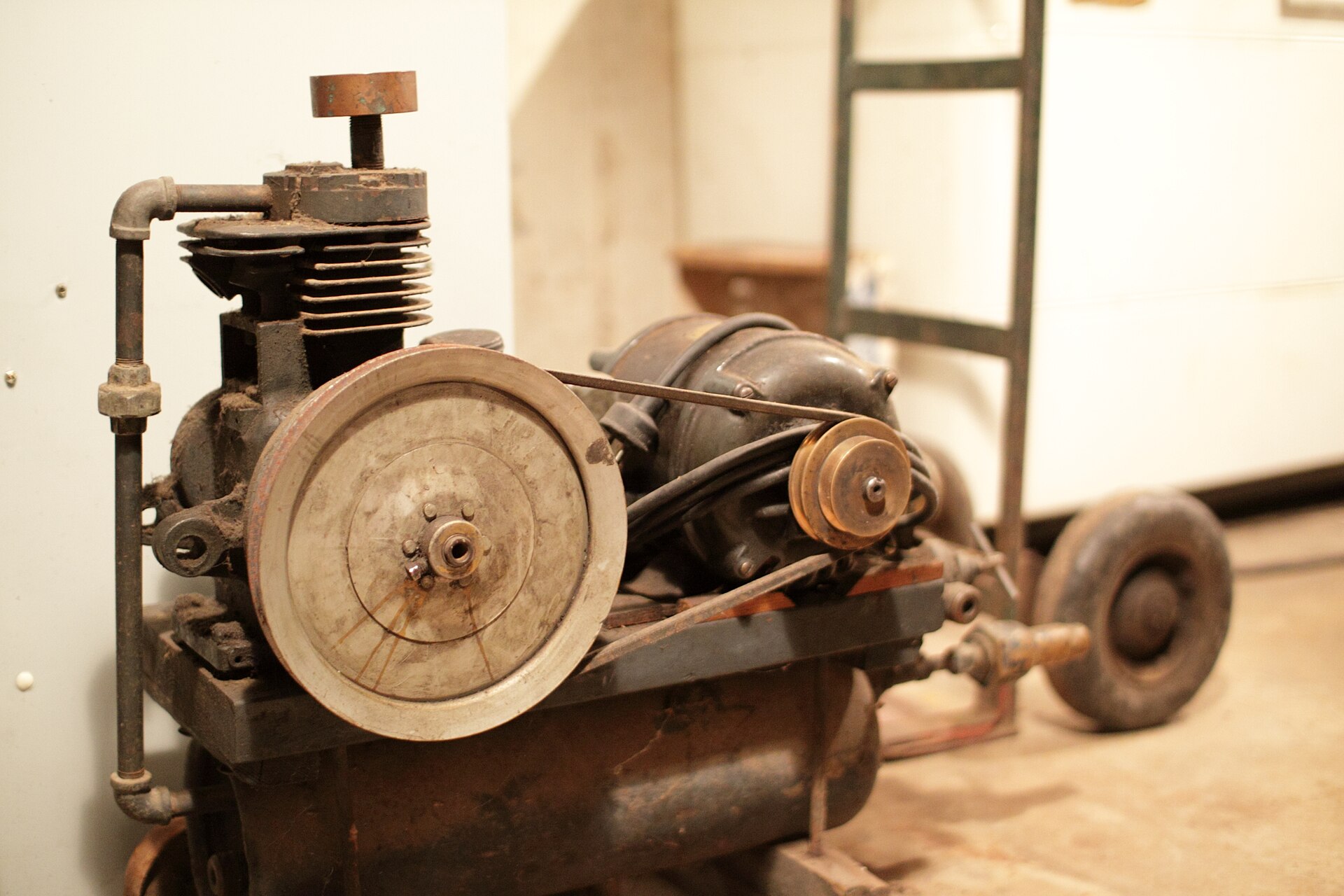 An old belt-driven piston air compressor mounted on its tank