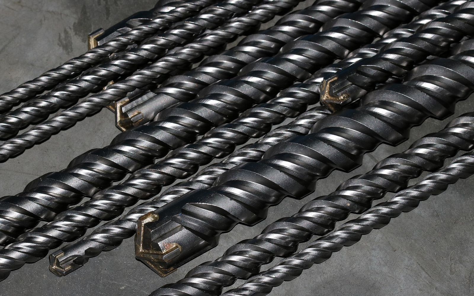 Carbide-tipped masonry drill bits of different diameters lying side by side