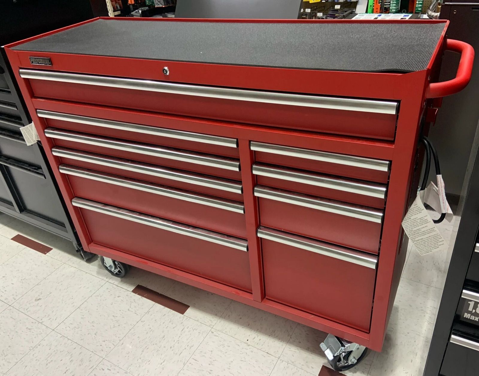 A red rolling tool cabinet with a row of full-width drawers and a side handle
