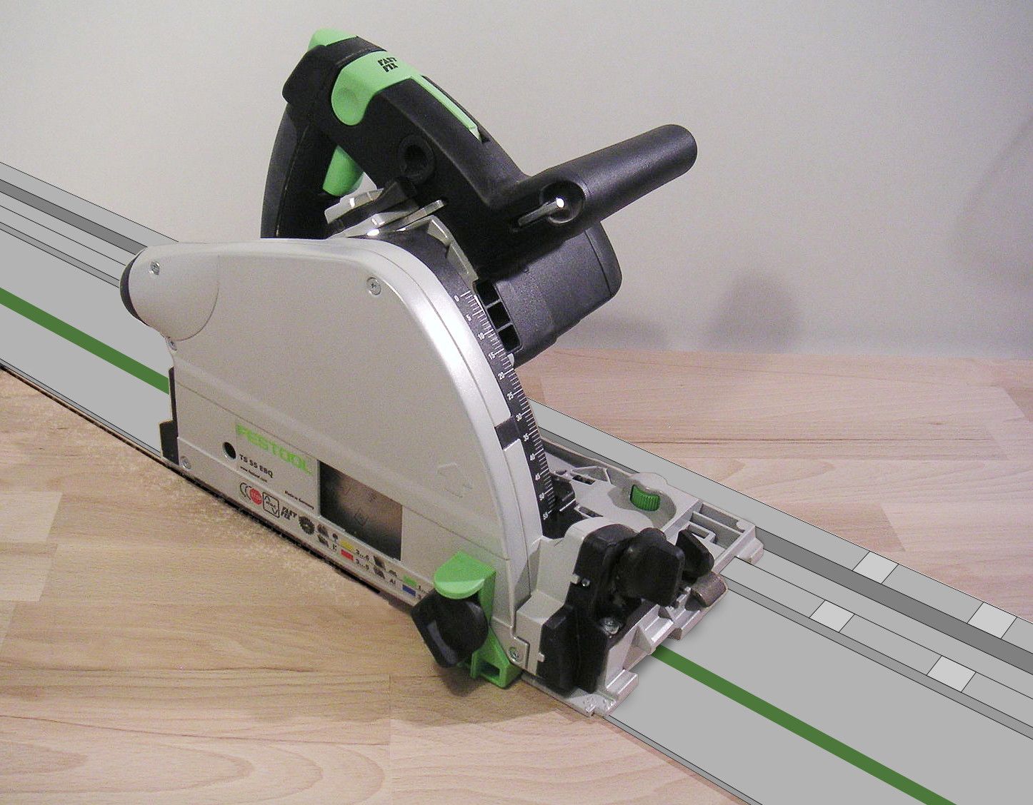 A plunge-cut track saw sitting on its aluminium guide rail on a wooden worktop