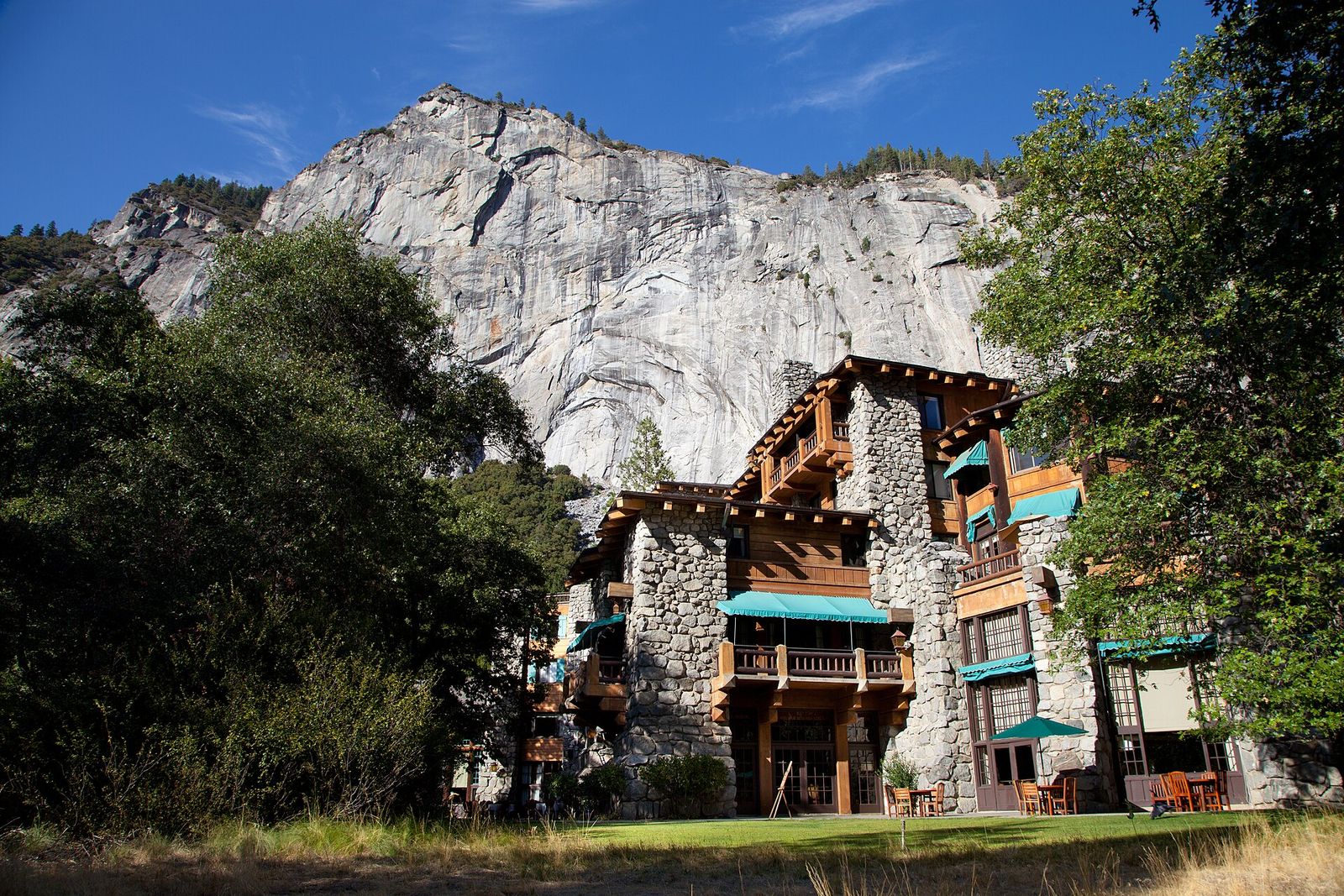 The Ahwahnee's stone and timber-toned facade below the granite cliffs of Yosemite Valley