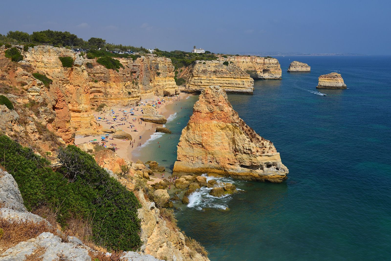 Golden limestone cliffs and sea stacks above the turquoise water at Praia da Marinha in the Algarve