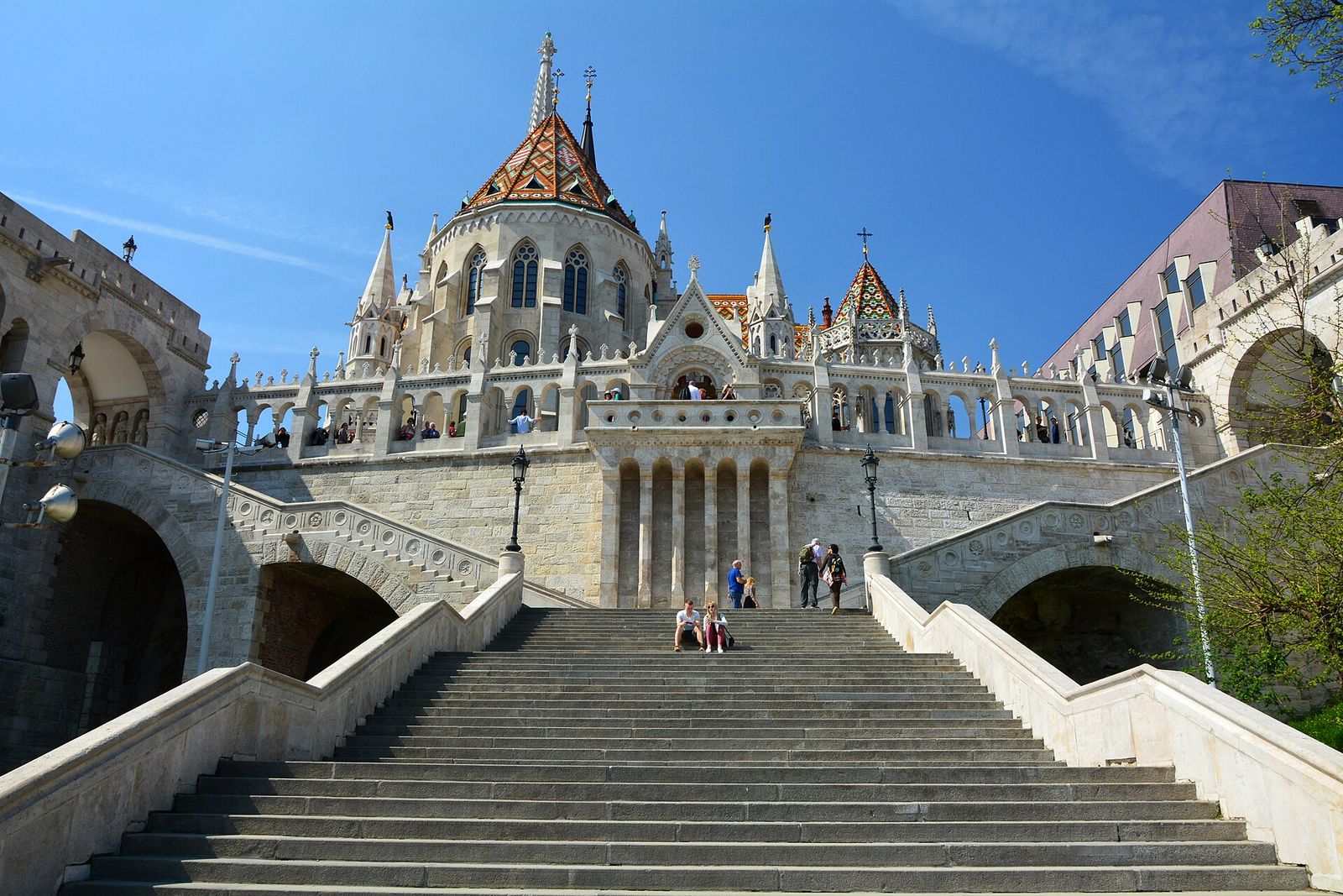 The white turrets and arcades of the Fisherman's Bastion below the tiled roof of Matthias Church on Castle Hill, Budapest
