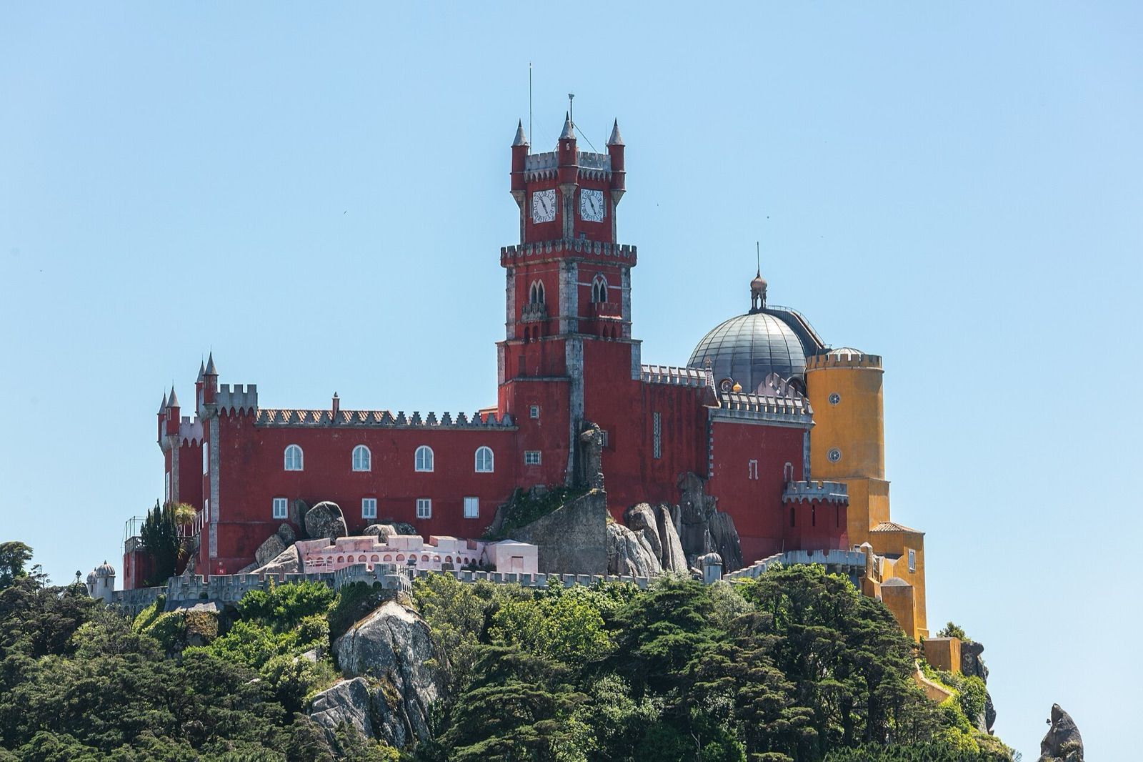 The red and yellow towers of the Pena Palace above the wooded hills of Sintra