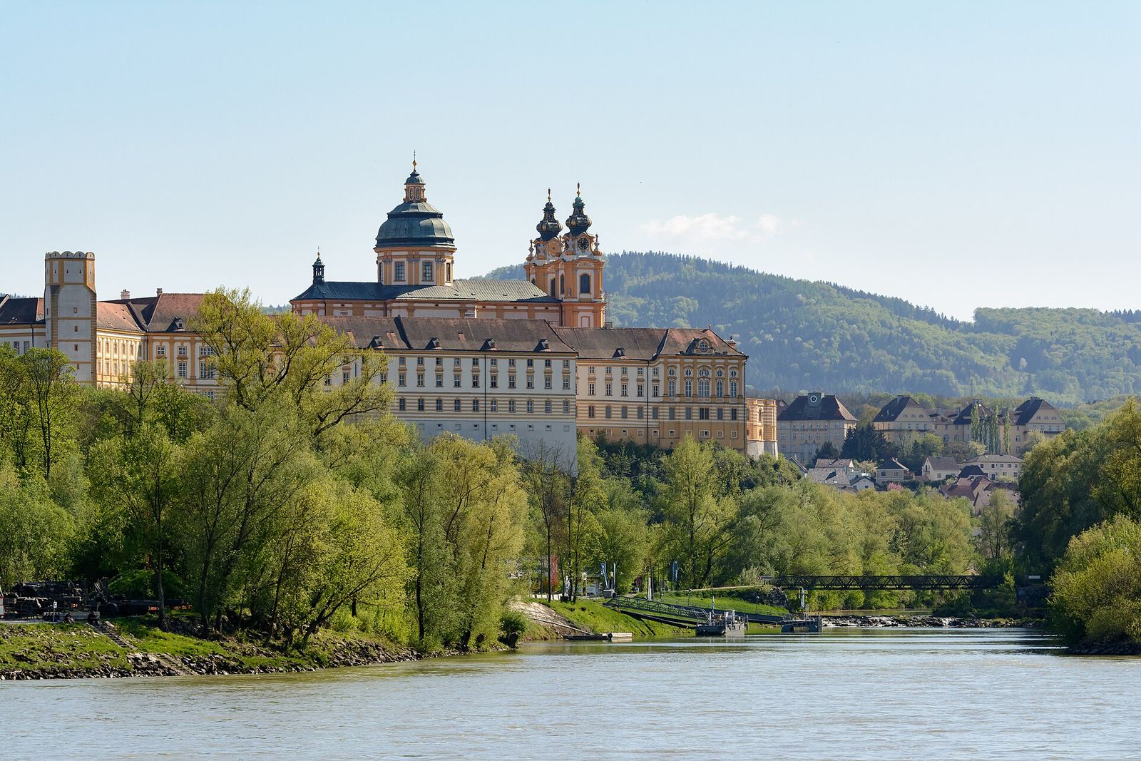Melk Abbey's long yellow baroque façade and twin towers above the town of Melk on the Danube