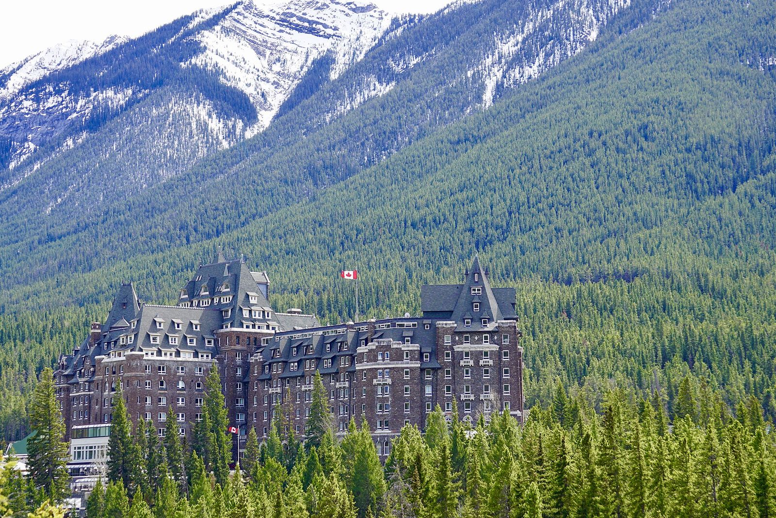 The stone turrets of the Fairmont Banff Springs rising above the forest in Banff National Park