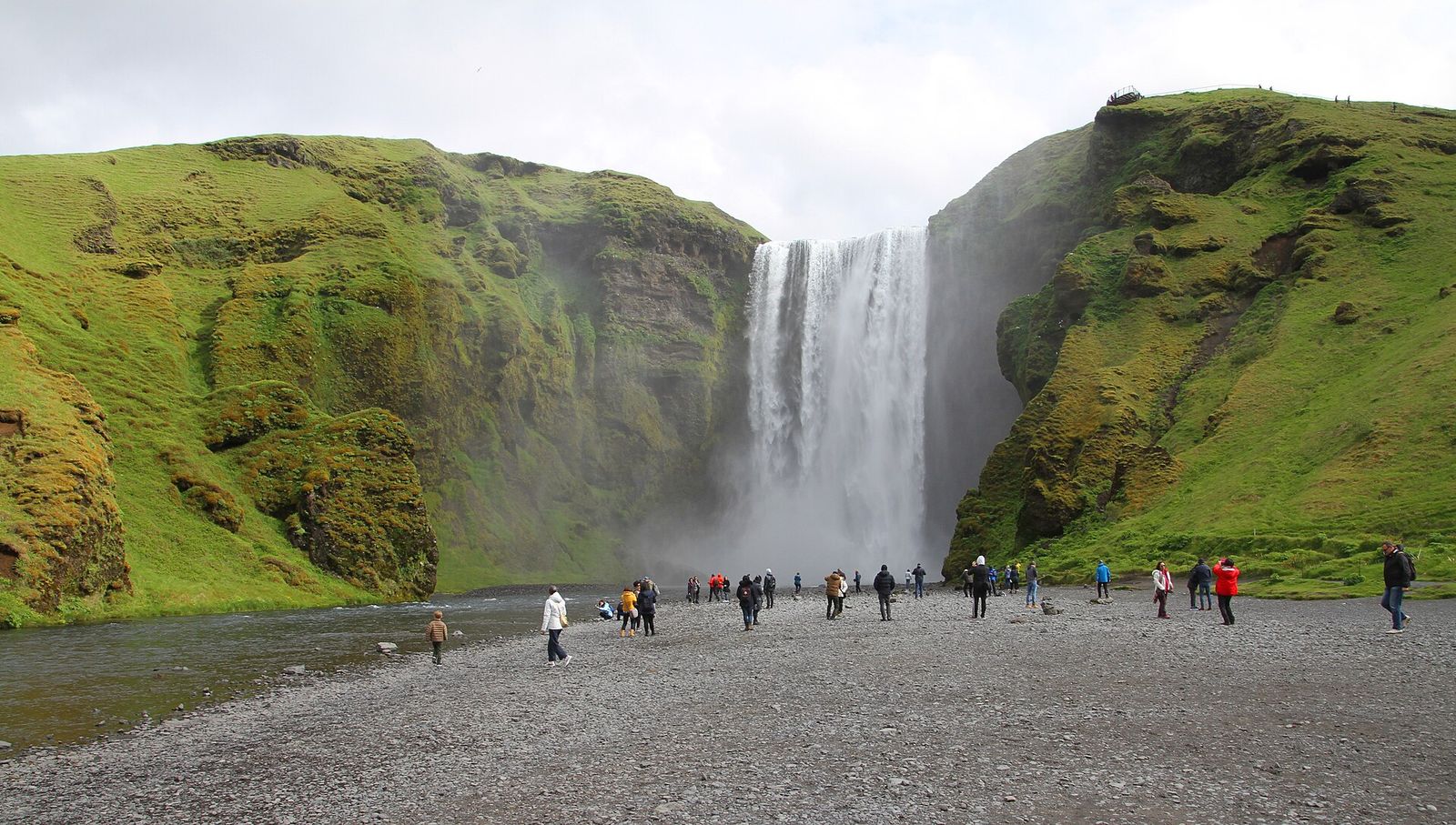 Skógafoss waterfall pouring over a green cliff on Iceland's South Coast