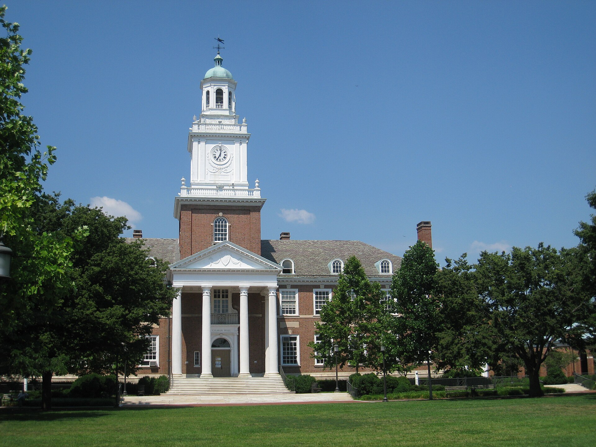 Gilman Hall's red brick and white clock tower on the Homewood campus of Johns Hopkins