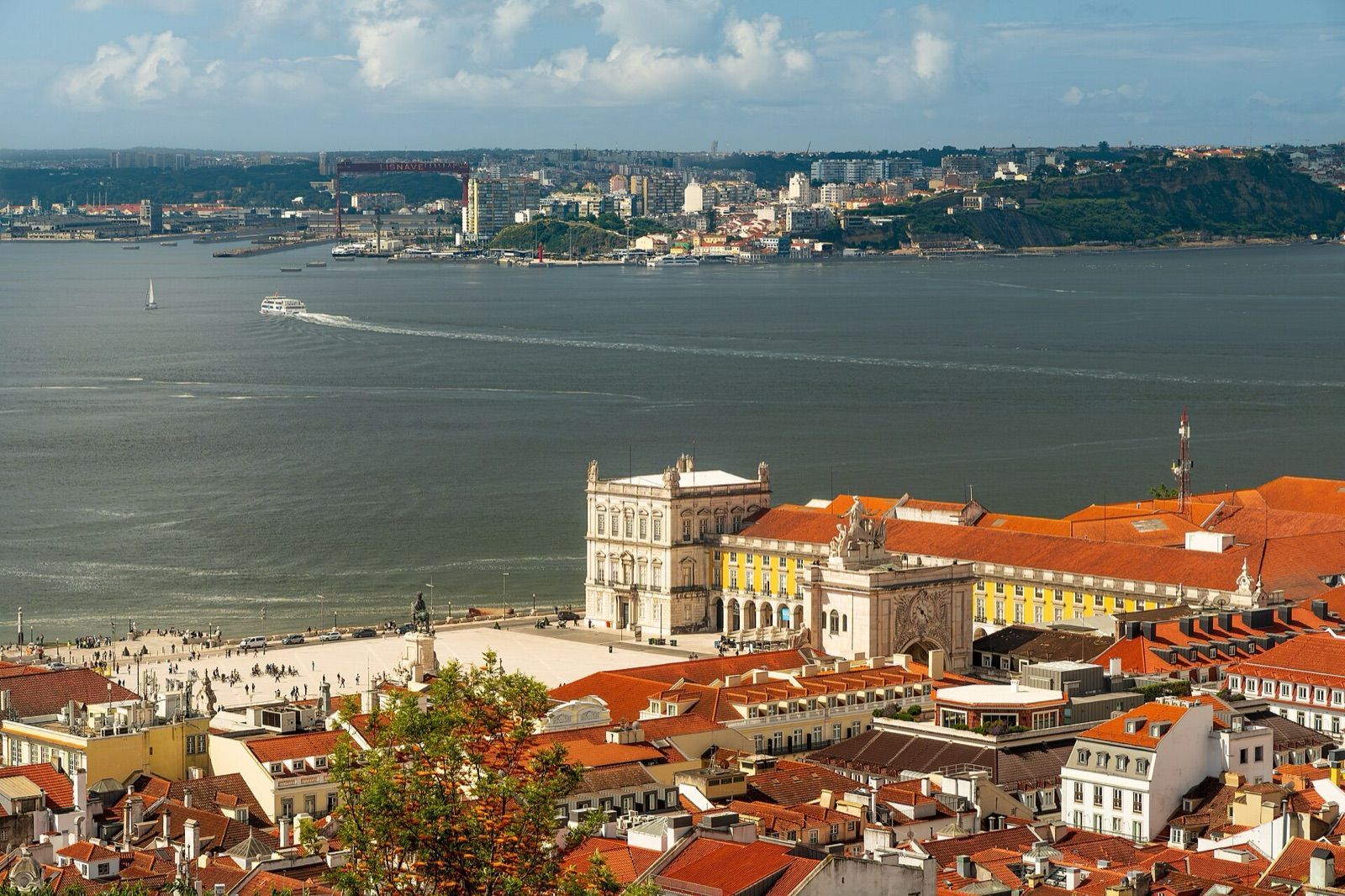 Praça do Comércio and the red rooftops of Baixa beside the Tagus river in Lisbon