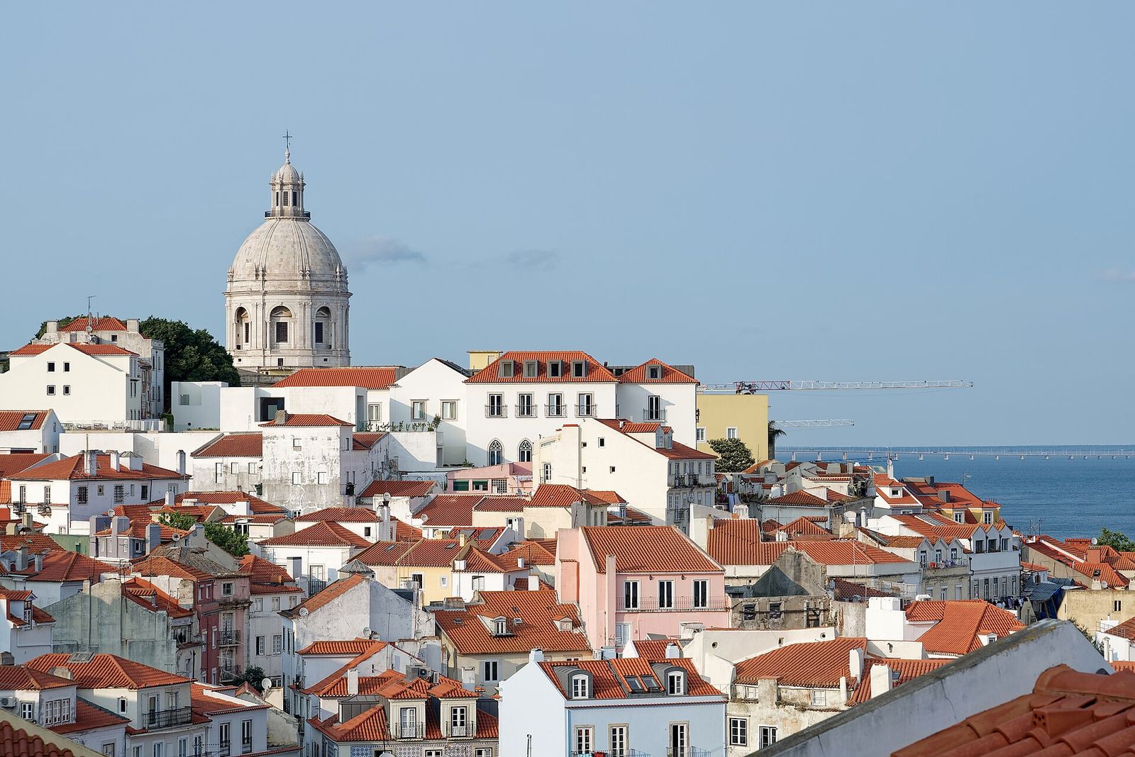 Red rooftops of the Alfama and the dome of the National Pantheon above the Tagus river in Lisbon