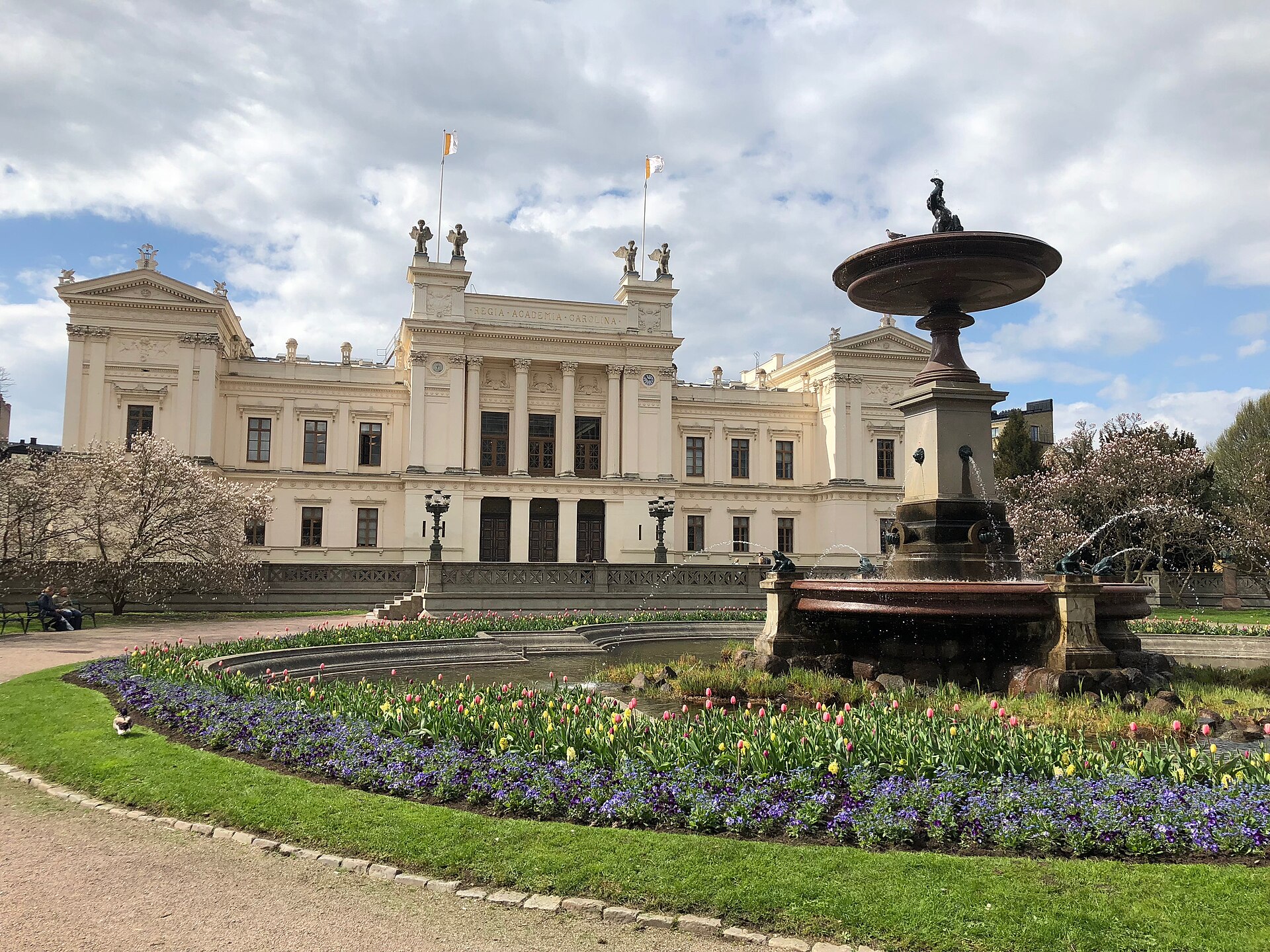 The white University Main Building of Lund University behind its fountain