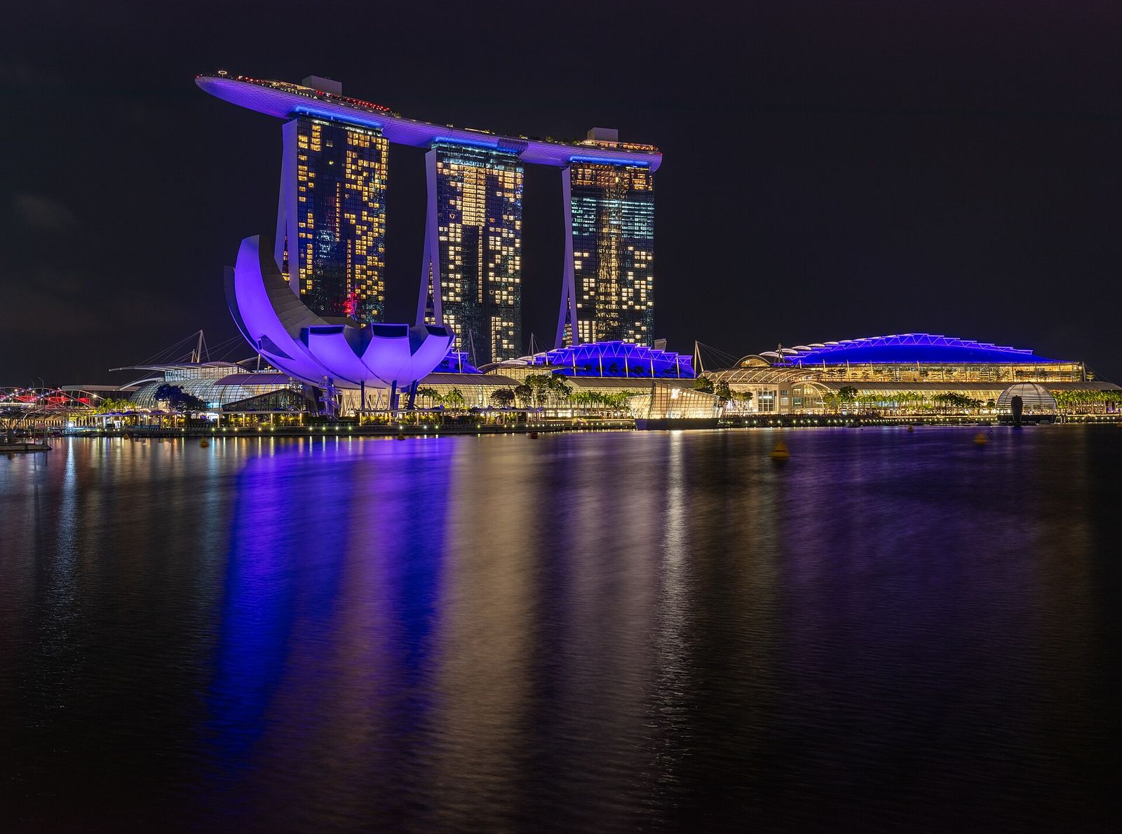 The three towers of Marina Bay Sands and the ArtScience Museum lit up at night on Marina Bay, Singapore