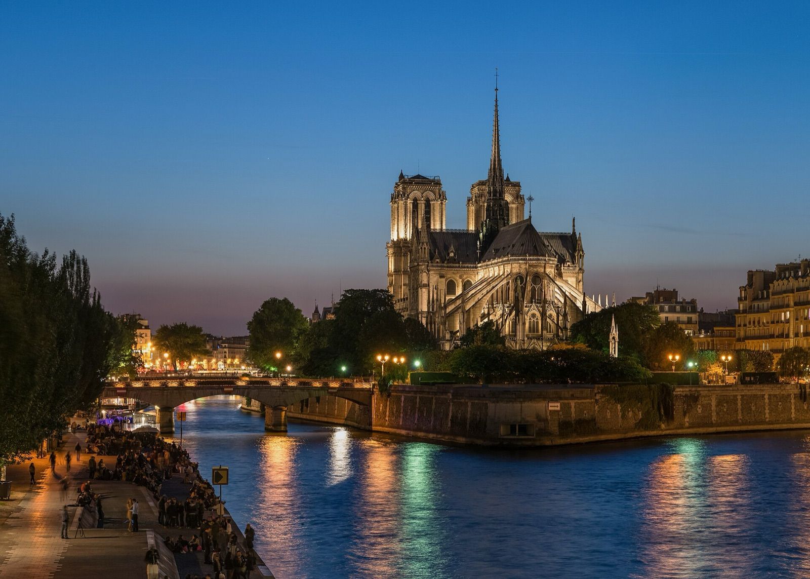 Notre-Dame cathedral and the Île de la Cité reflected in the Seine at dusk