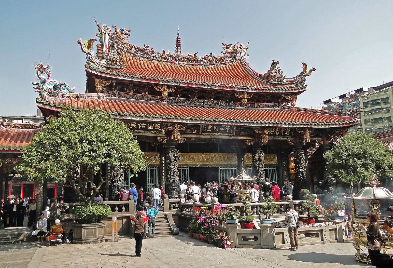 The ornate curved roofs and dragon carvings of the main hall of Longshan Temple in Wanhua, Taipei