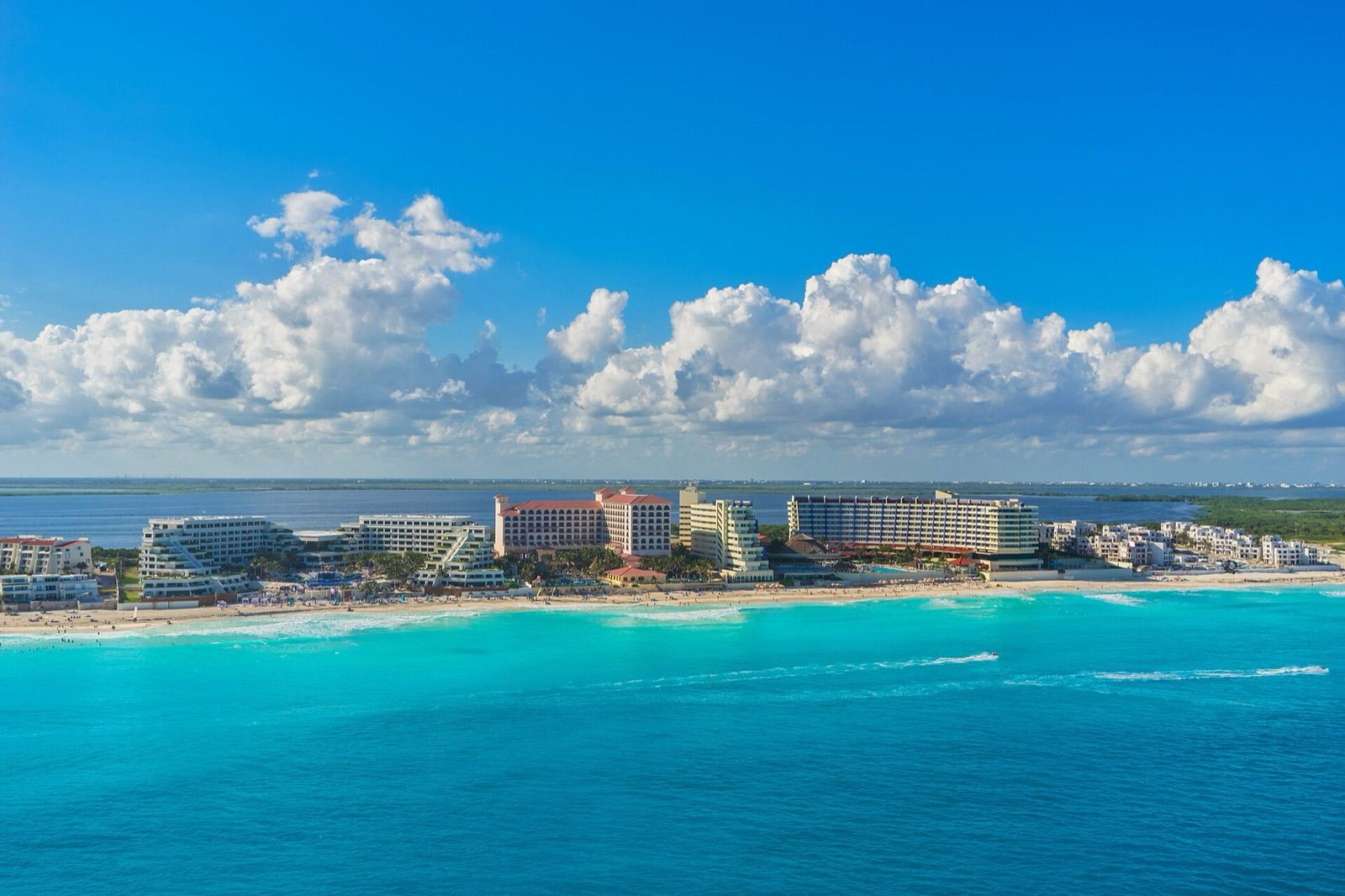 Turquoise Caribbean water and beach in front of the resort strip of the Cancún Hotel Zone