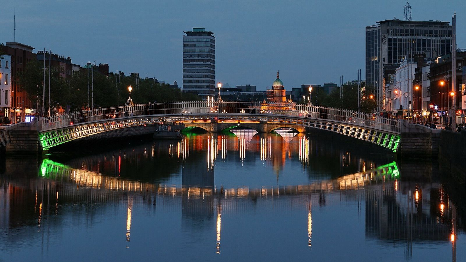 The Ha'penny Bridge lit up at dusk over the River Liffey in Dublin