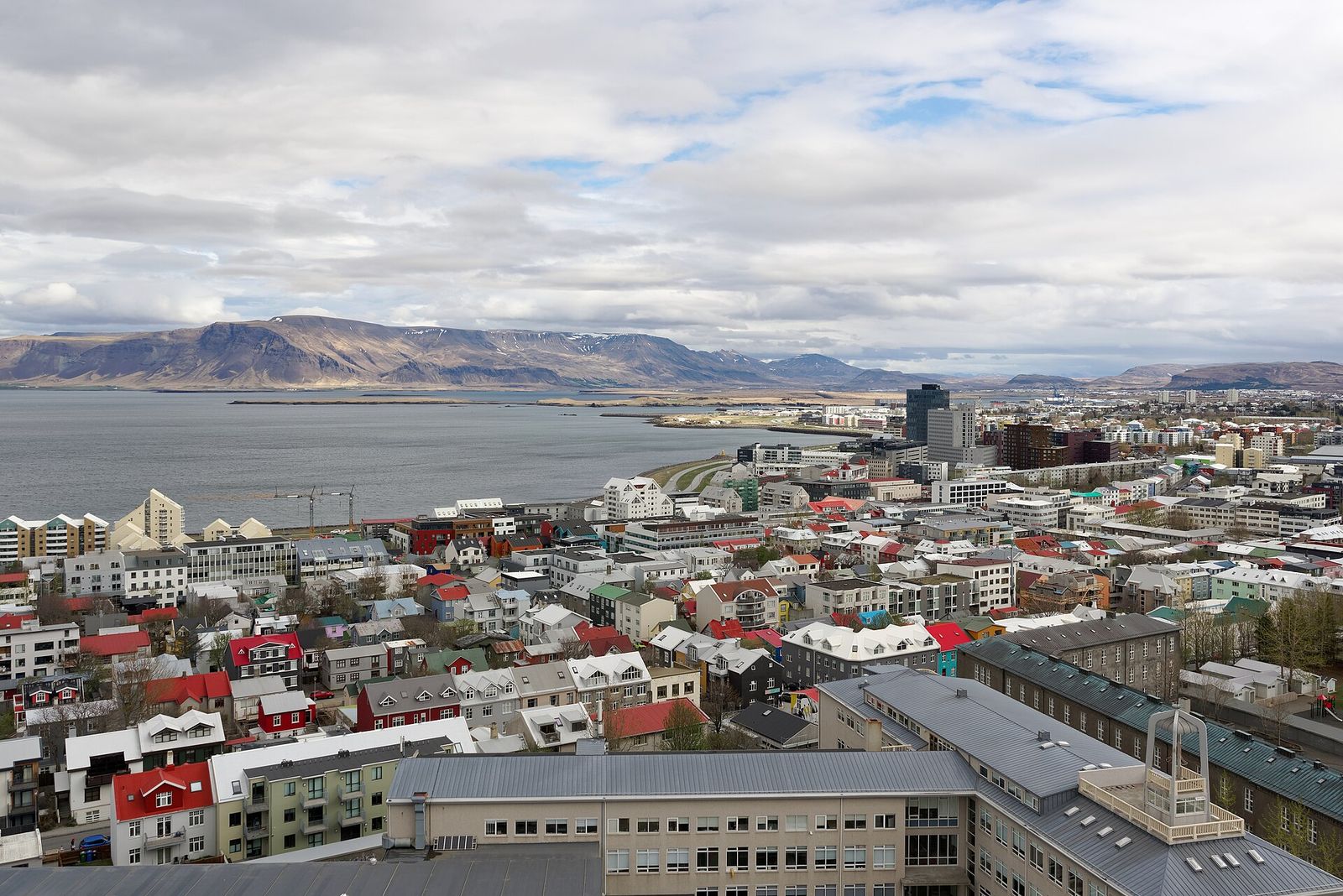Colourful rooftops of central Reykjavík seen from Hallgrímskirkja, with Mount Esja across the bay