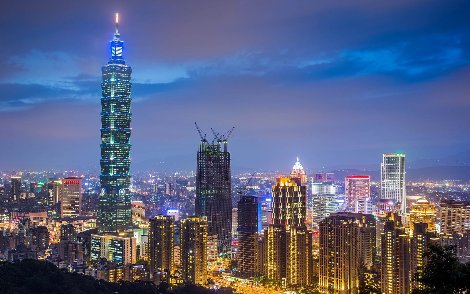 Taipei 101 and the towers of the Xinyi district lit up at dusk